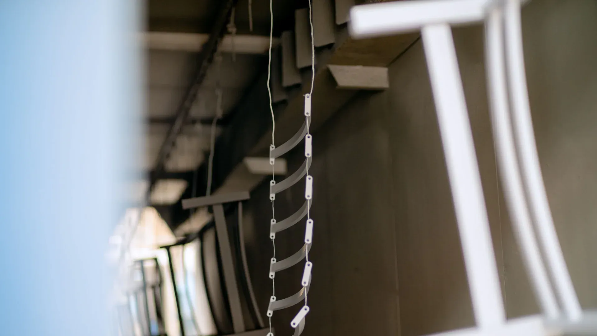 Close-up of industrial metal parts hanging in a coating process, showcasing manufacturing details