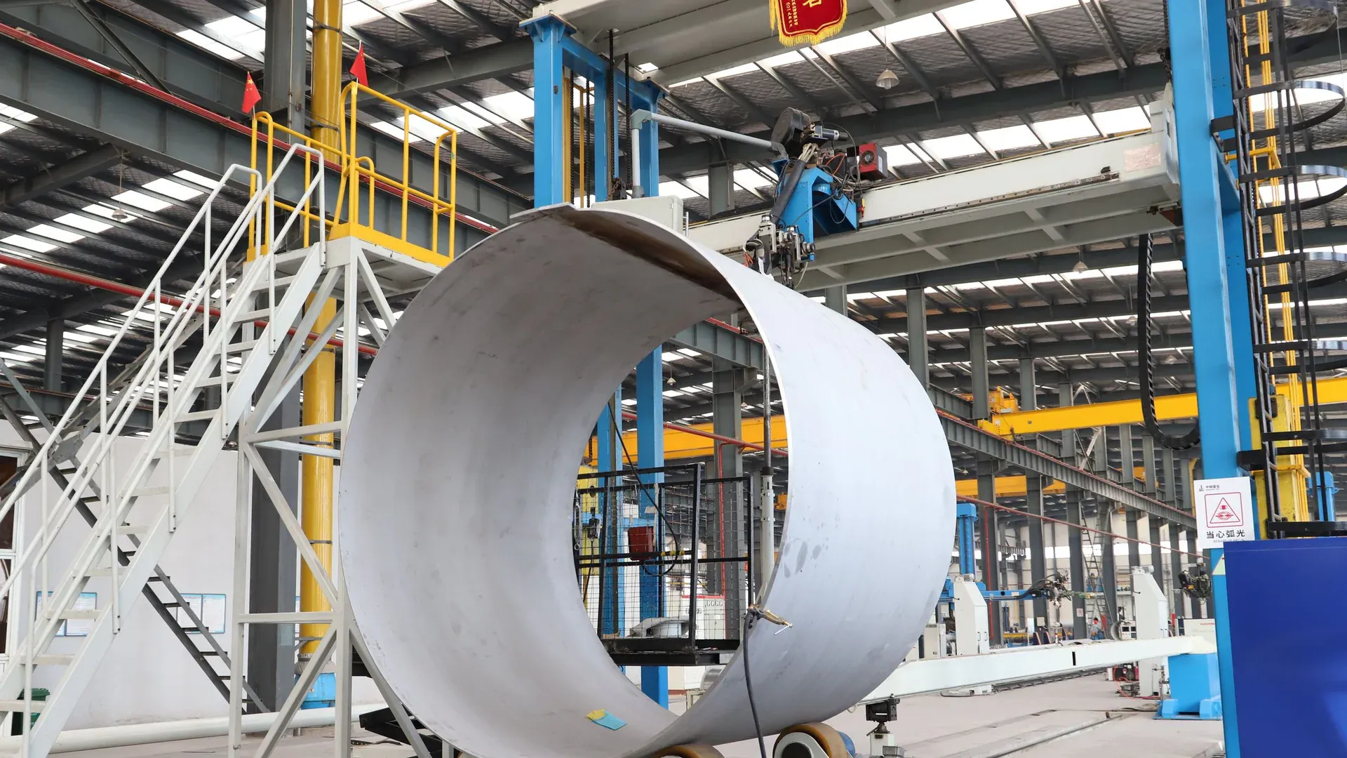 A spacious industrial factory scene showcasing steel pipe production with modern machinery