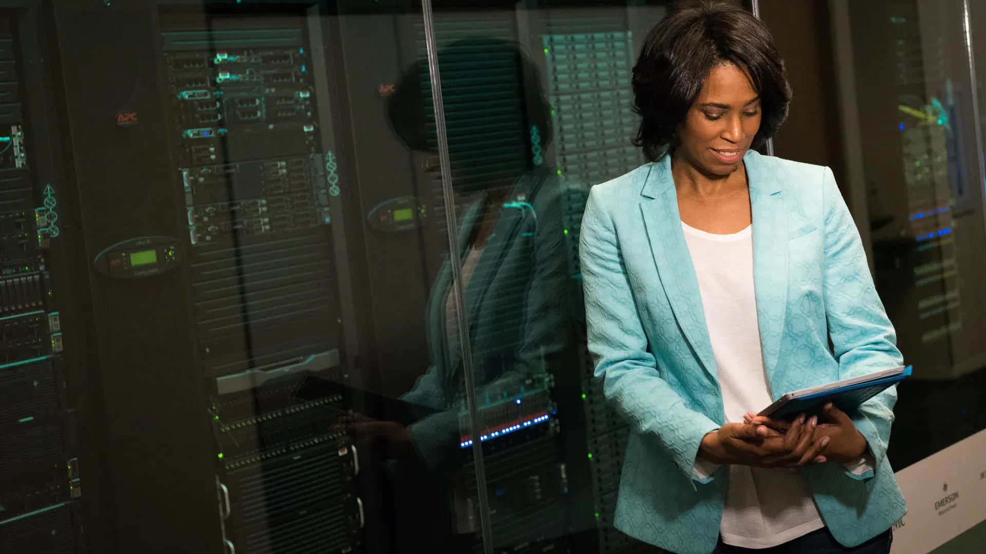 Female IT professional examining data servers in a modern data center setting