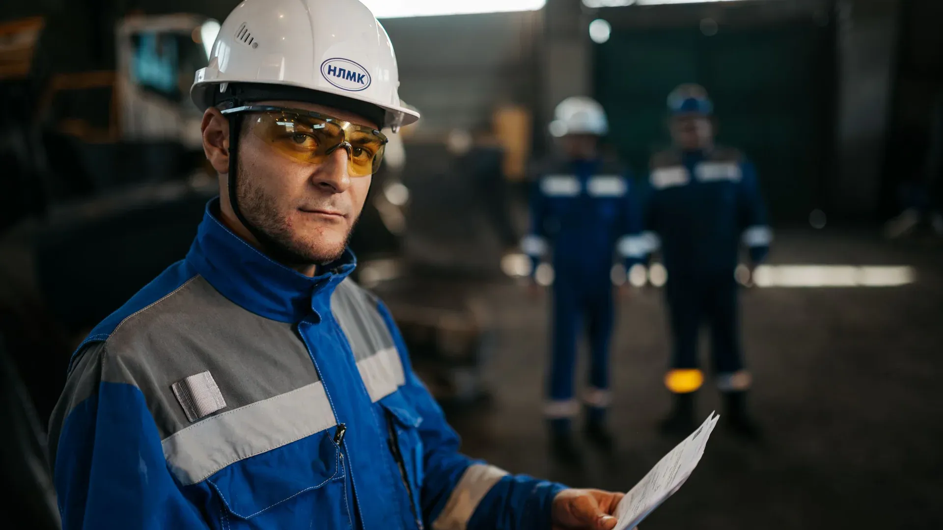 Industrial worker reviewing technical documents beside production equipment