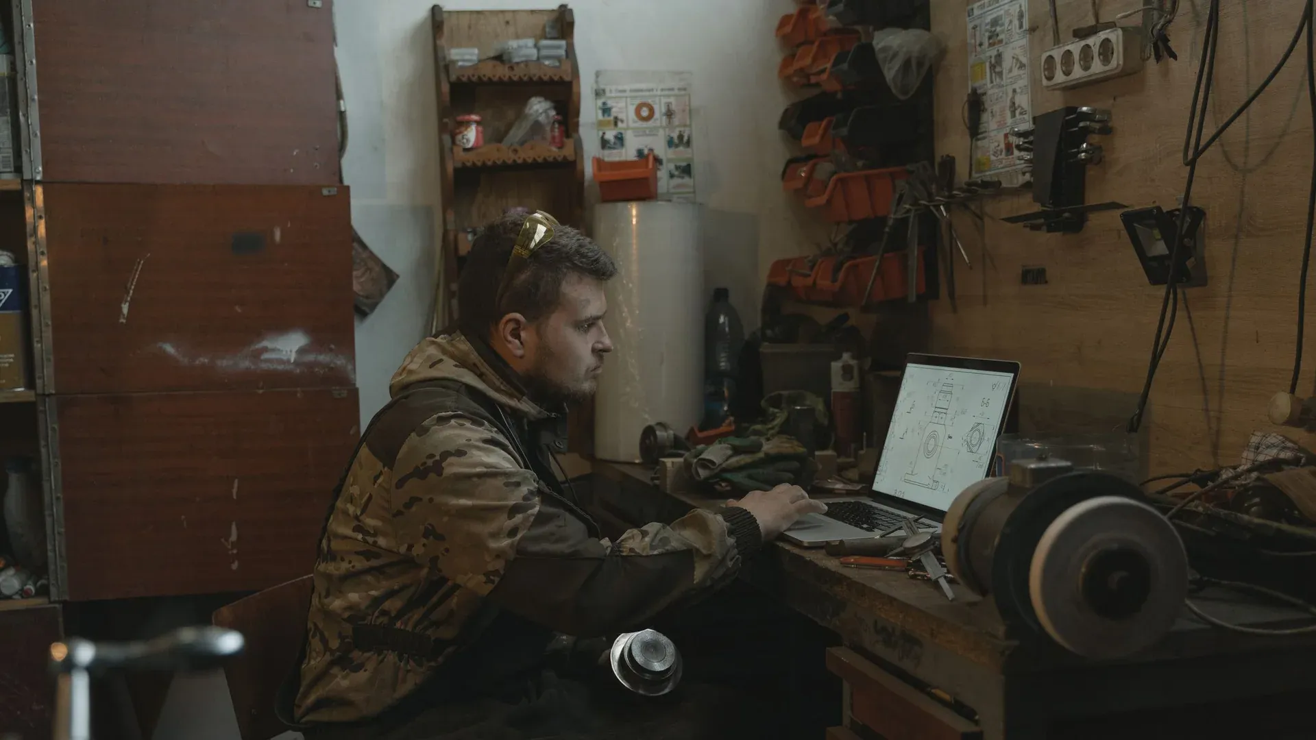 Engineer using a laptop in a workshop during industrial equipment support