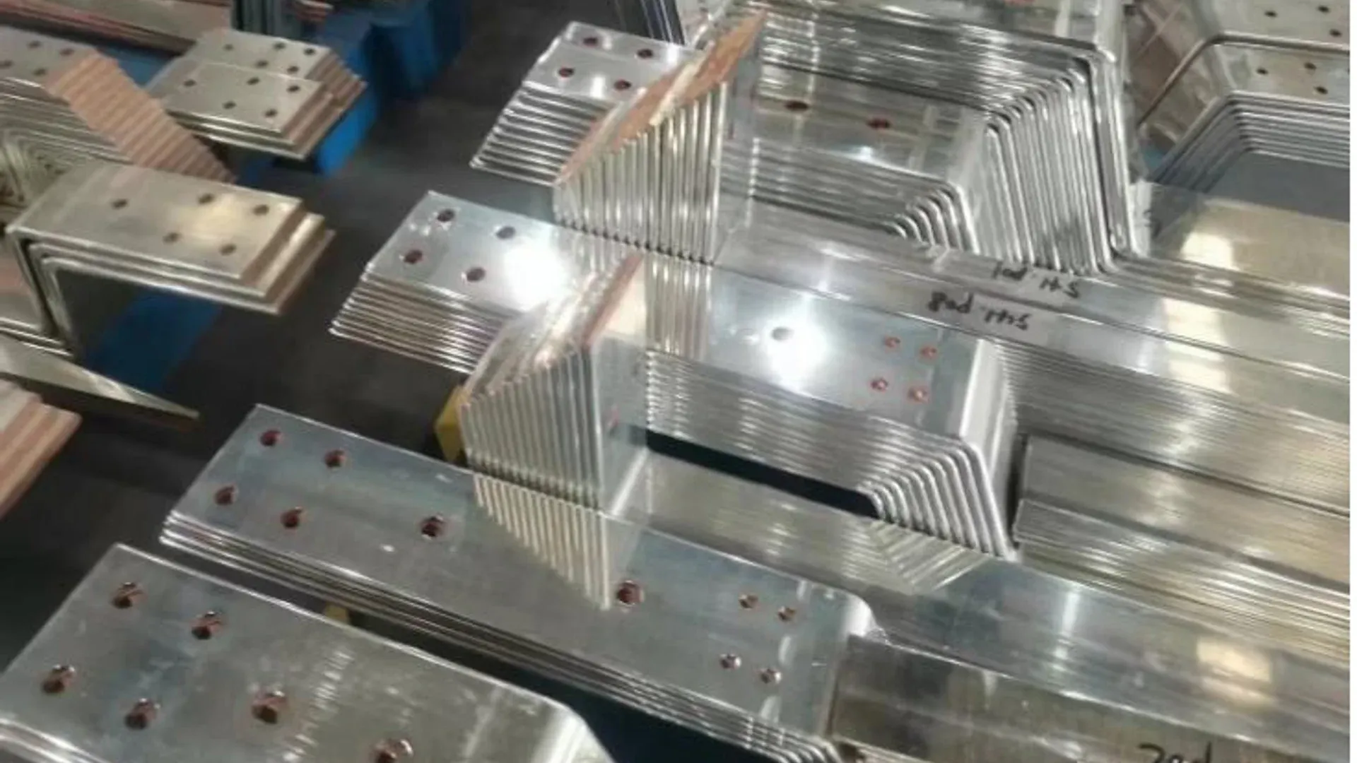 Finished punched and bent busbar parts grouped by switchgear panel family
