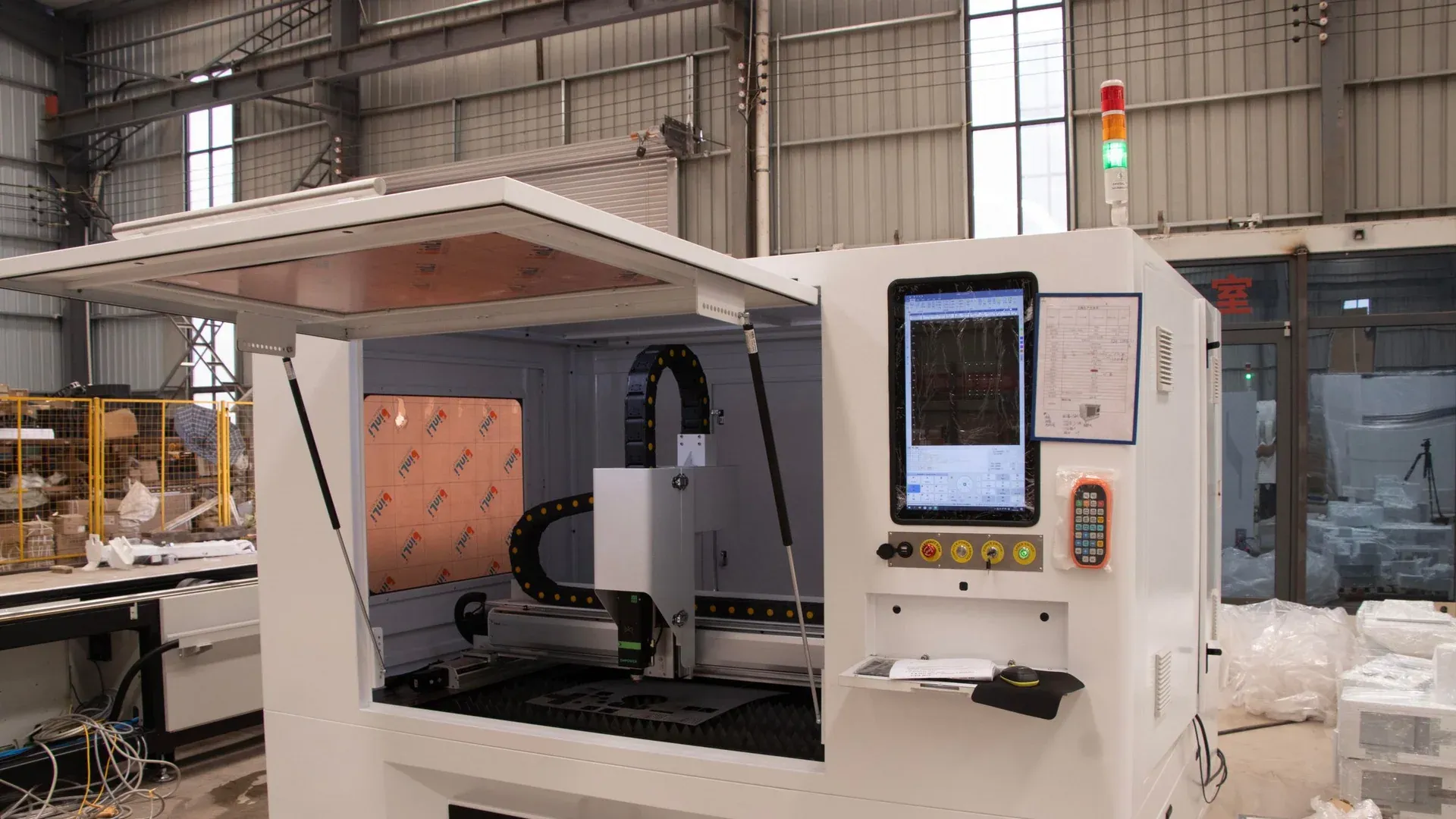 A CNC machine and digital operator control on a factory floor