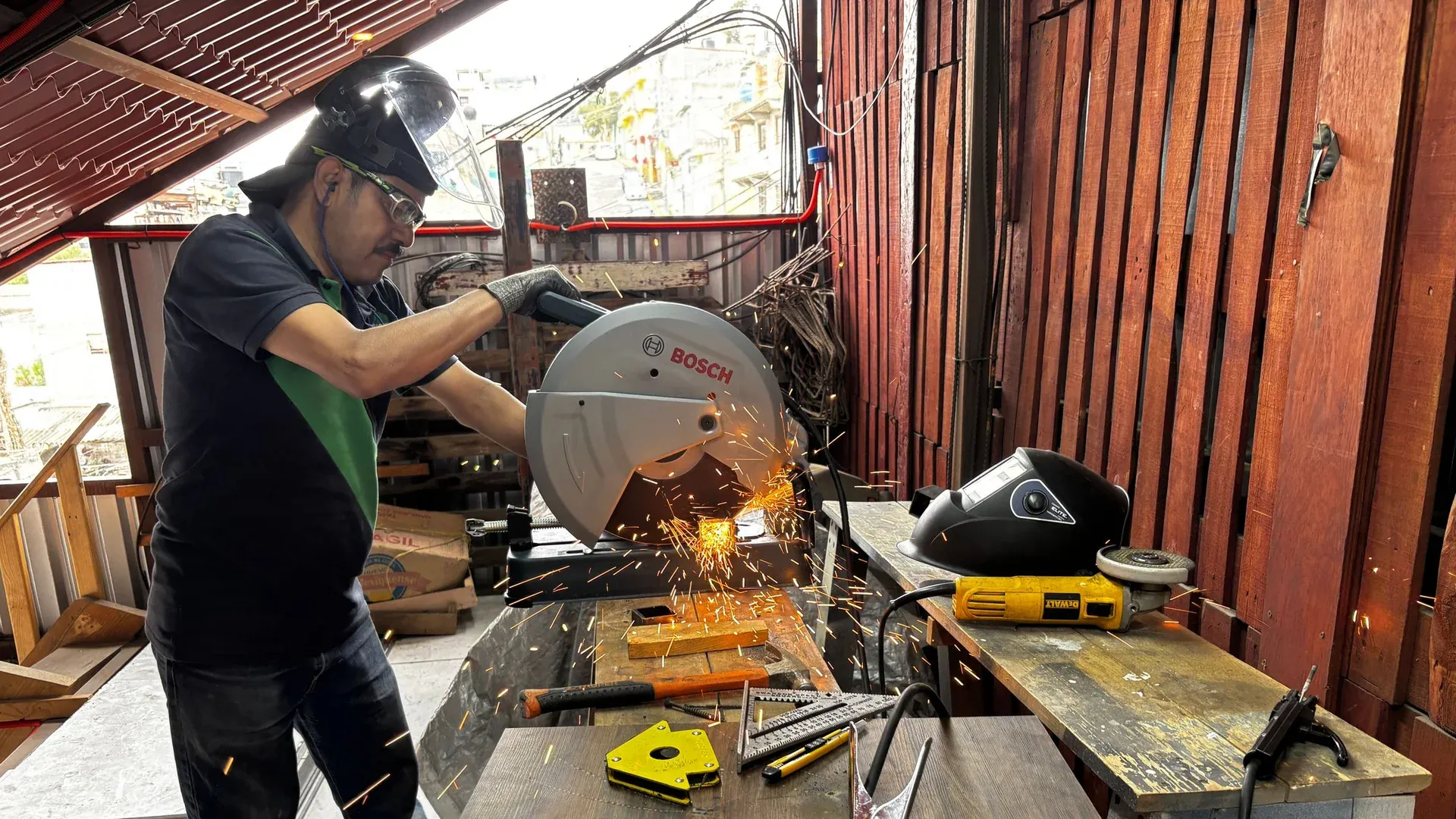 An operator cutting metal stock with an industrial saw