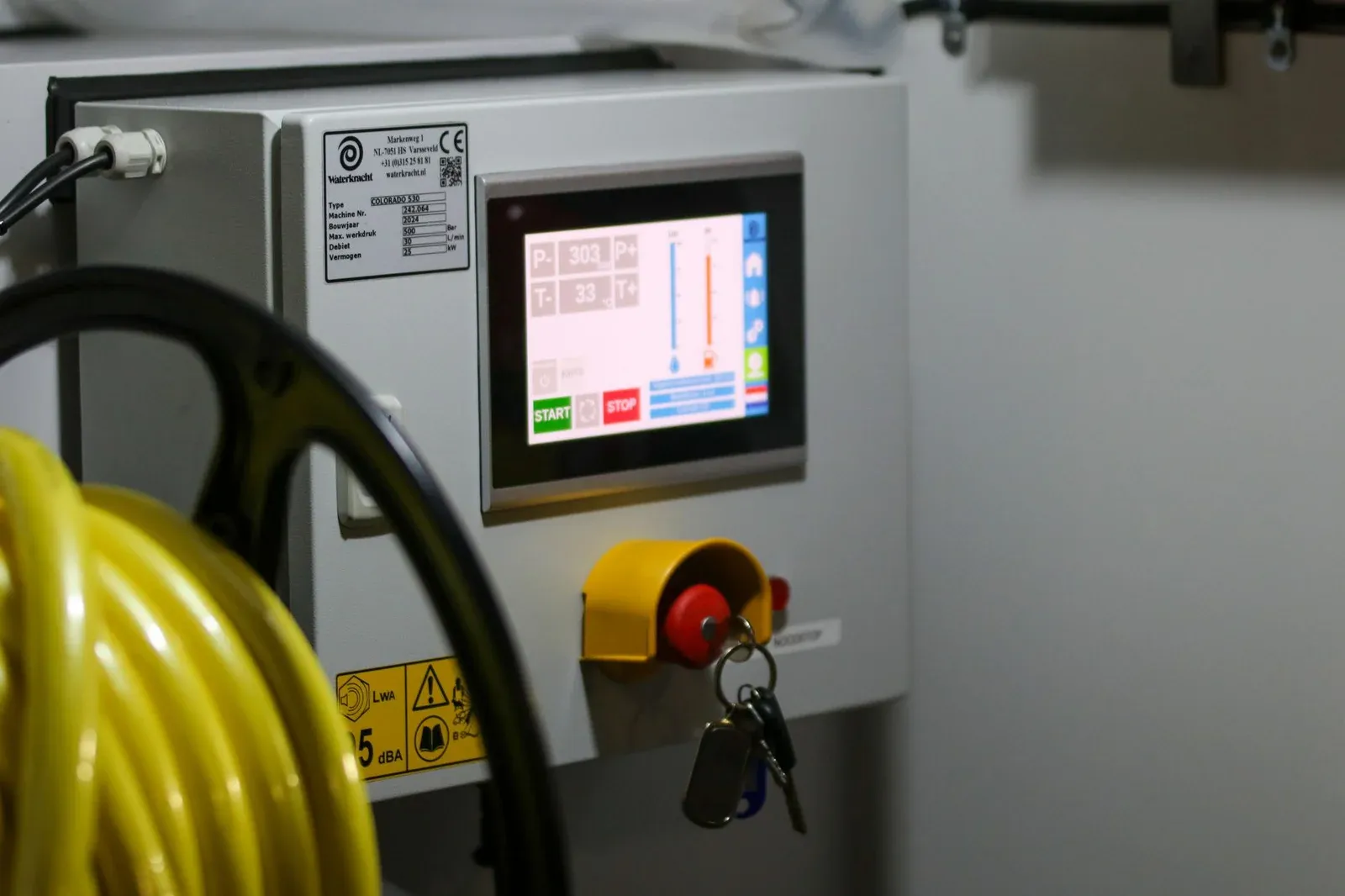 Industrial machine control panel with a display and emergency stop controls