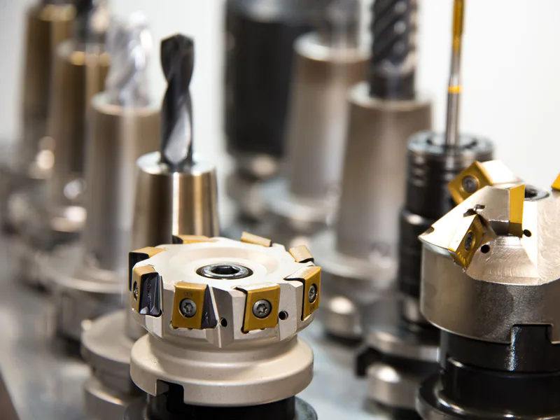 Detailed view of various metal drill bits and tools arranged in a workshop setting