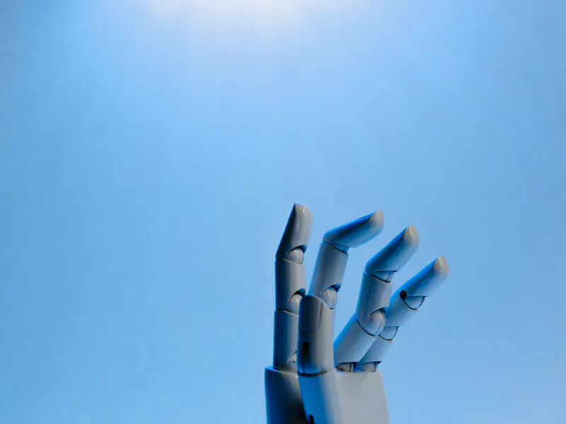 Robotic hand with articulated fingers reaching towards the sky on a blue background