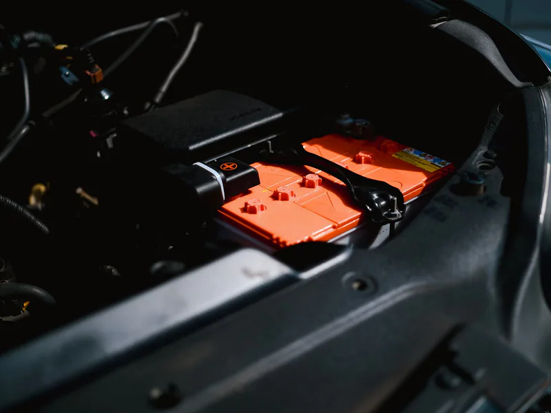 Detailed view of an electric car battery inside a vehicle’s engine compartment, highlighting sustainable technology
