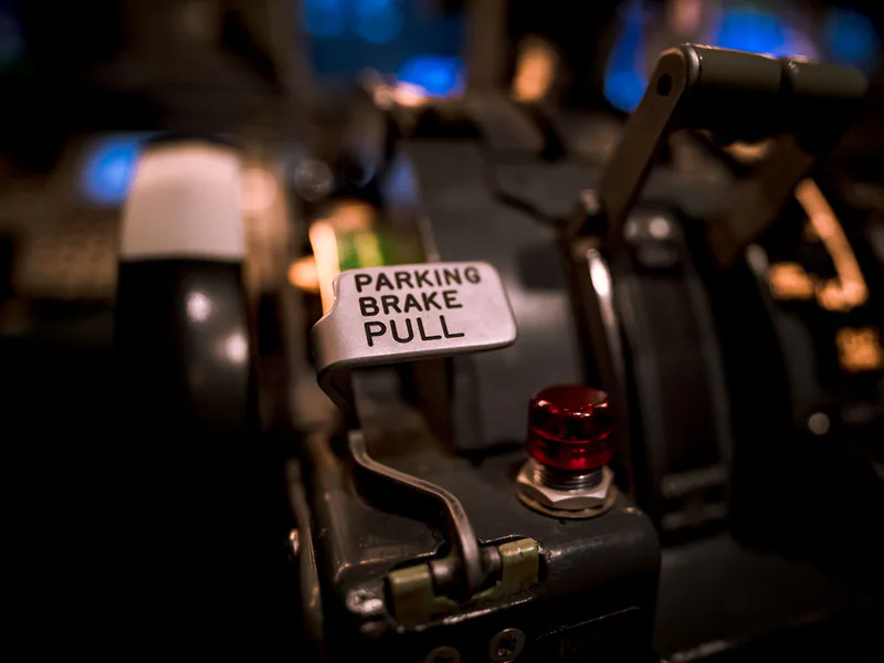Detailed view of an aircraft parking brake lever with selective focus in a cockpit