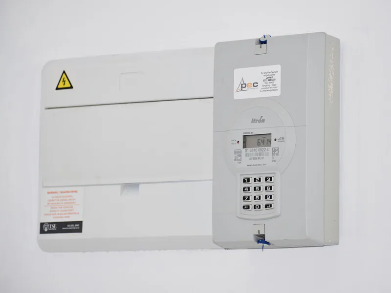 Electrical meter and fuse box on a white wall in Cape Town, South Africa, for energy monitoring or billing