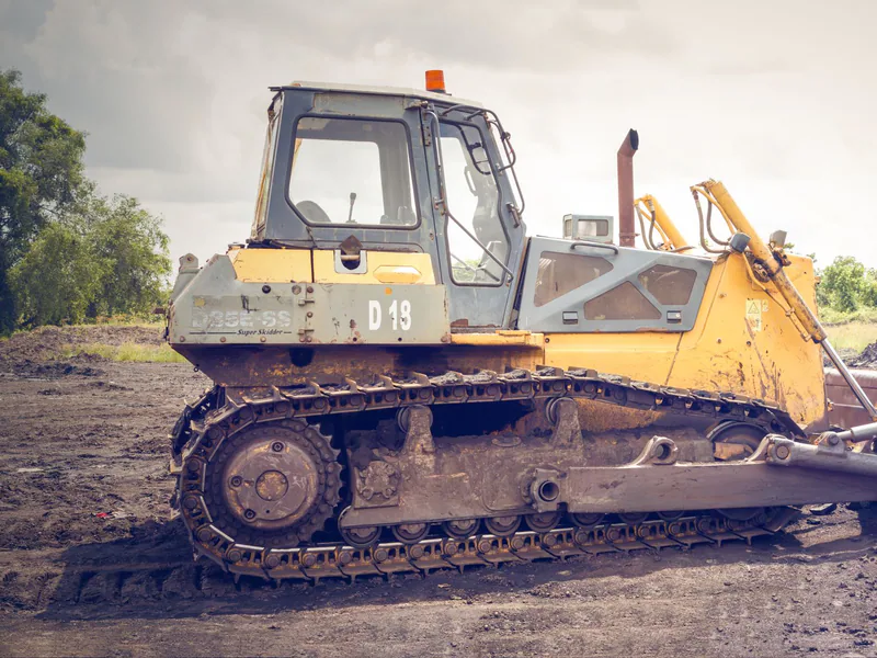 A powerful bulldozer on muddy construction ground under a cloudy sky