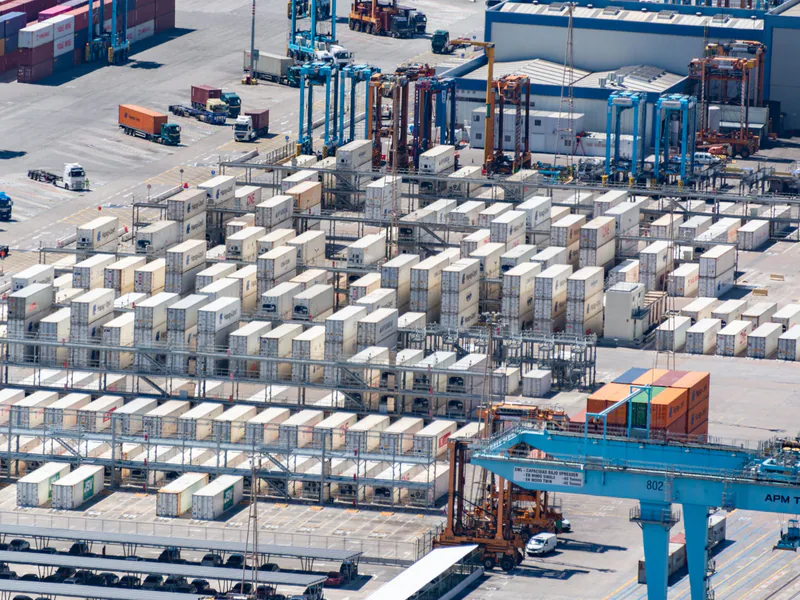 Bird’s eye view of a logistics warehouse with shipping containers and trucks
