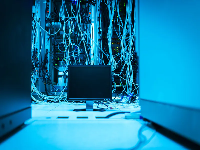 Technician laptop connected to dense server-rack cabling