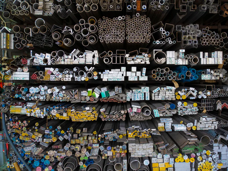 Mixed metal bars, tubes, and profiles organized in warehouse bins