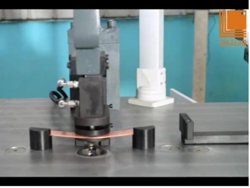 A formed copper busbar held in a measurement fixture